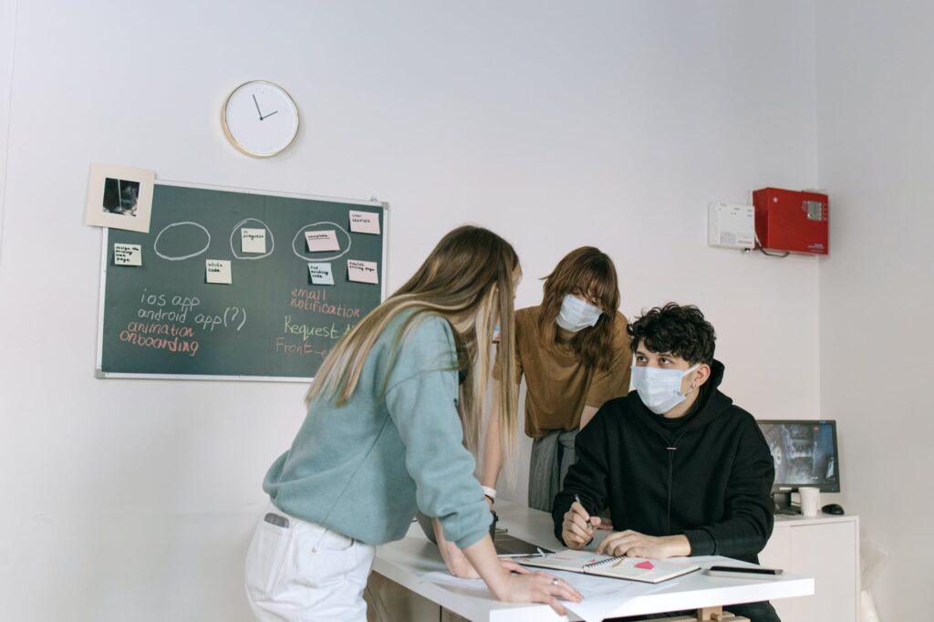 a group of people talking while wearing face mask